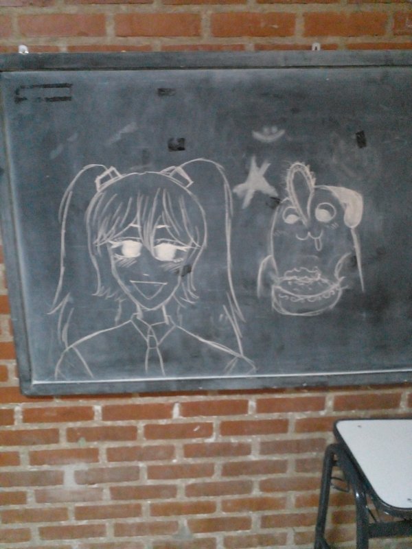 A blackboard with a drawing of Hatsune Miku and Pochita from Chainsawman eating cake.